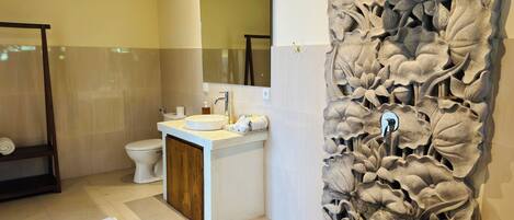 A modern bathroom with a large bathtub, a sink, and a toilet.