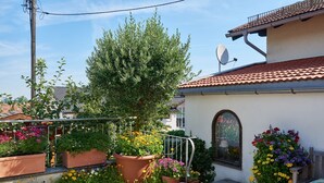 Ein Wohnhaus mit Garten, Satellitenschüssel und kleiner Terrasse.