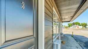 A building entrance with a garage door marked with the number 3, a covered parking area, and a clear view of the street. - Comfy and Cozy Studio for 2 (101 Spring Creek) (Kalispell)