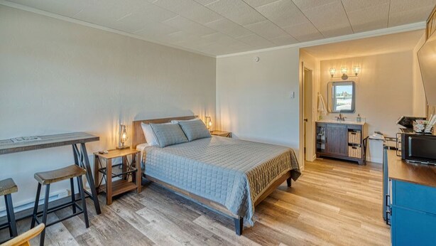 A bedroom with a bed, a desk, and a dresser. - Comfy and Cozy Studio for 2 (101 Spring Creek) (Kalispell)