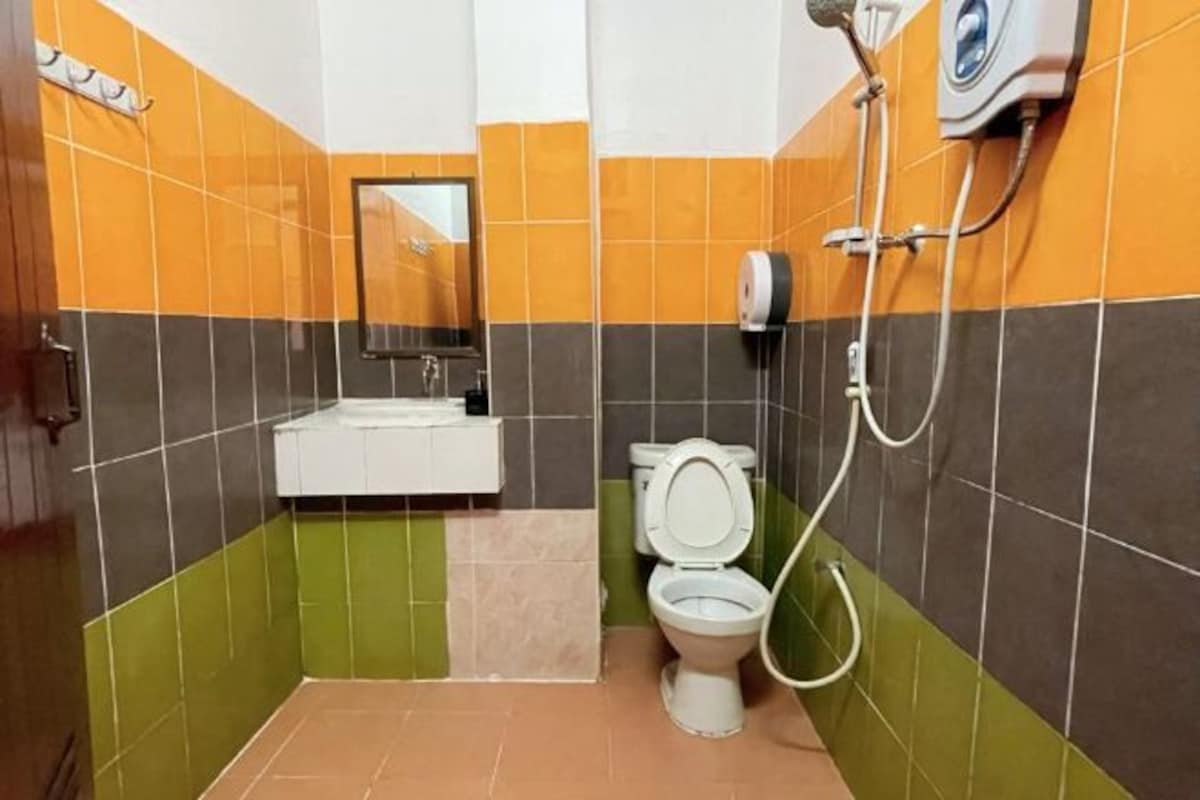 Une salle de bain équipée de toilettes, d’un lavabo et d’une douche.