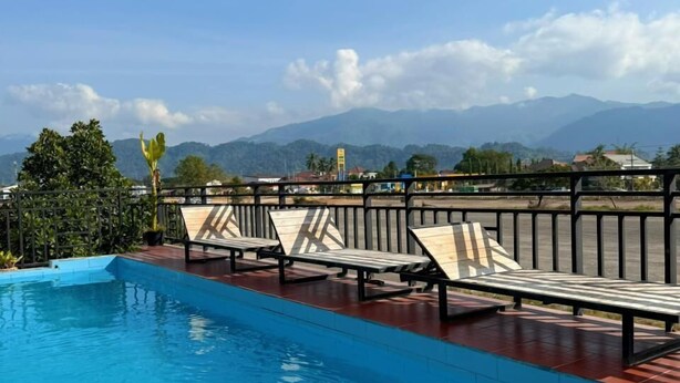 Une piscine avec des chaises longues et une vue sur les montagnes.