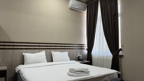 A hotel room with a bed, white bedding, a nightstand with a phone, and a window with curtains. - Rayyan Hotel EXPRESS (Salor)
