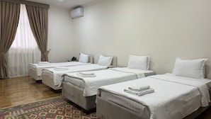 A hotel room with four single beds, a telephone, and a wall-mounted air conditioner. - Rayyan Hotel EXPRESS (Salor)