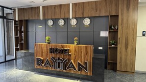 A hotel reception desk with clocks displaying different time zones, a wooden reception area, and a marble floor. - Rayyan Hotel EXPRESS (Salor)