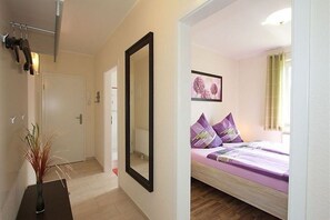 Ein Schlafzimmer mit einem Bett, einem Spiegel und einer Tür.