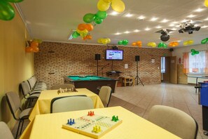 Um quarto com mesa de bilhar, mesa de futebol e uma televisão.