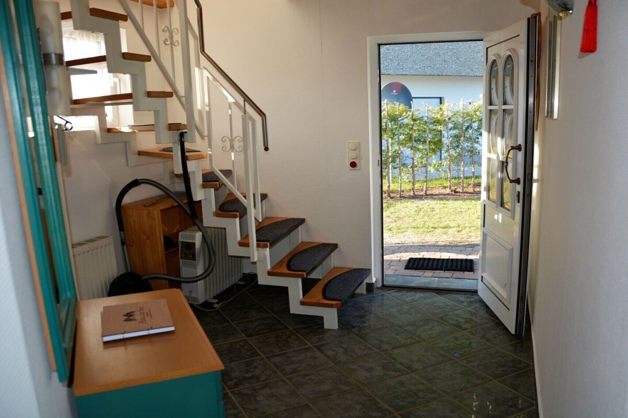 Una escalera que lleva a una puerta con vista a un jardín.