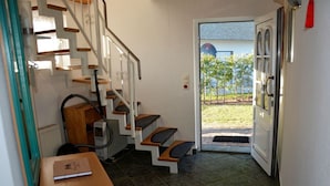 Eine Treppe führt zu einer Tür mit Blick auf einen Garten.