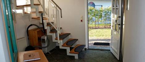 Un escalier menant à une porte donnant sur un jardin.