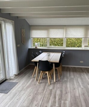 Enjoy meals in this dining area with a table and six chairs, surrounded by a view of lush greenery.