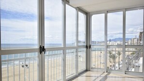 A spacious room with large windows offering a view of a beach and cityscape. - MAR Y VENT - SEA VIEW (3 BEDROOMS) (Benidorm)