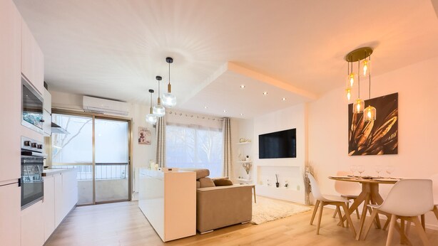 A modern living space with a kitchen, dining area, and seating area.