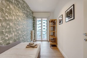 A bedroom with a bed, a wardrobe, and a door leading to a balcony. - Easylife - Cozy & Comfy apt in design district (Milano)