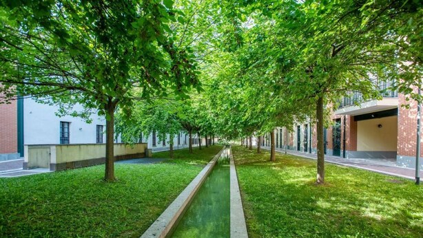 A tree-lined pathway with a narrow water feature, flanked by buildings with brick and white facades. - Amazing flat with a view and terrace on Navigli by Easylife (Milano)