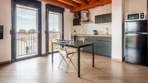A modern kitchen with a dining area, large windows, and a view of the city. - Amazing flat with a view and terrace on Navigli by Easylife (Milano)