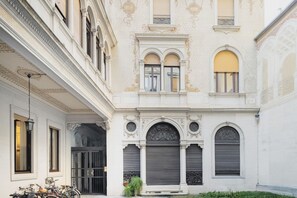 Un edificio histórico con detalles arquitectónicos ornamentales, incluyendo un arco central y molduras decorativas.
