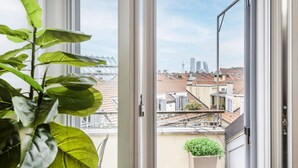 Een balkon met uitzicht op een stadsgezicht, inclusief gebouwen en een toren.