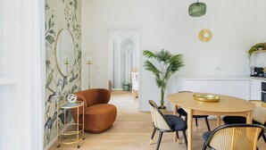 A modern dining area with a wooden table, chairs, and a potted plant.