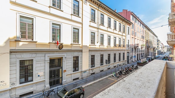 A street view with a building featuring large windows and a balcony. - Easylife - Luxury and Comfort in Brera district (Milano)