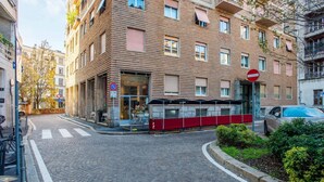 A multi-story building with a brick facade, a no entry sign, and a red barrier in front. - Easylife-Spacious and comfortable apartment in the Duomo (Milano)