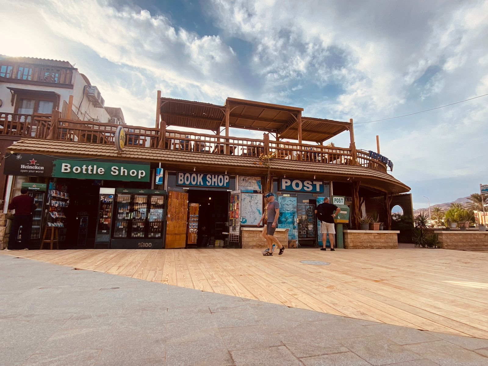 Un edificio de madera que alberga una oficina de correos, una librería y una tienda de vinos.