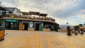 A wooden deck with a post office, a bottle shop, and a book shop.