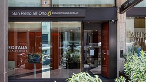 A modern building with a glass facade, labeled "San Pietro all' Orto 6 Exclusive Living in Milan." - Amazing apartment in Duomo by Easylife (Milano)