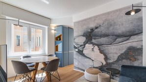 Un espace repas moderne avec une table ronde, des chaises et un buffet bleu.
