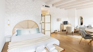 A modern hotel room with a large bed, a desk, and a seating area. - Easylife - Exclusive penthouse with panoramic view (Milano)