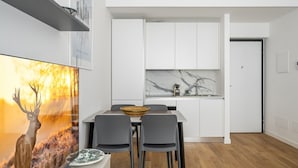 Een moderne keuken met witte kasten en een marmeren achterwand.