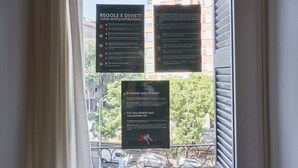 Uma janela com três placas informativas sobre regras e proibições, procedimentos de check-out e um lembrete sobre o processo de saída.