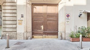 Uma grande porta dupla de madeira com uma placa e um aviso de proibido estacionar.