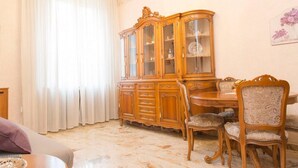 A dining area with a wooden cabinet, a table, and upholstered chairs. - Easylife - Elegant and cozy apt in Città Studi (Milano)
