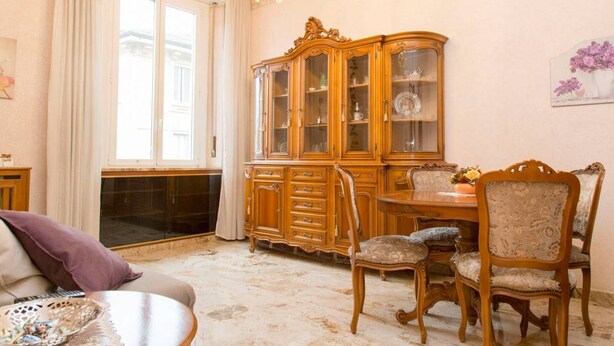A room with a large wooden cabinet, a dining table with chairs, and a chandelier. - Easylife - Elegant and cozy apt in Città Studi (Milano)