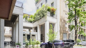 A modern building with a courtyard, a car parked in front, and a no parking sign. - Easylife - Elegant studio apartment in Corso Magenta (Milano)