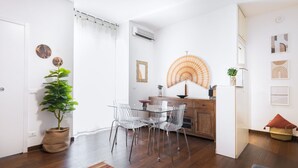 Una cocina moderna con comedor, armarios de madera y una planta en maceta.