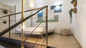 Une chambre moderne avec un lit, un escalier et une vue sur l’espace de vie.