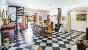 Un espace repas avec un sol à carreaux, un escalier en colimaçon et une cheminée.