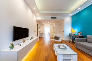 Ein modernes Wohnzimmer mit Flachbildfernseher, Couchtisch und Sofa.