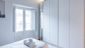 A bedroom with a bed, a window, and a wardrobe.