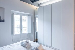 A bedroom with a bed, a window, and a wardrobe.