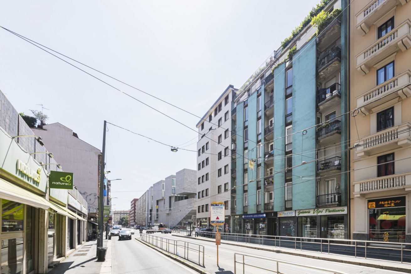 A street with buildings, a tram line, and a sign for a restaurant.