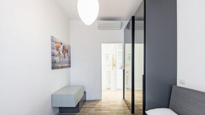Ein modernes Schlafzimmer mit einem Bett, einer Bank und einem Bild an der Wand.