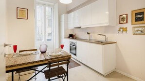 Une cuisine moderne avec des armoires blanches, un comptoir en granit et un four encastré.
