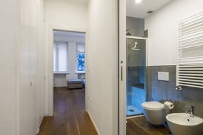 A modern bathroom with a glass shower enclosure, a toilet, and a sink.
