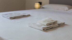 Un lit bien fait, avec des serviettes blanches pliées.