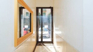 A corridor with a large mirror on the left and a door at the end. - Easylife - Spacious and new apt in Città Studi (Milano)