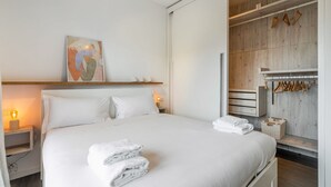 A modern hotel room with a large bed, a wooden wardrobe, and a painting on the wall. - Easylife - Comfort in Pta Romana with terrace (Milano)