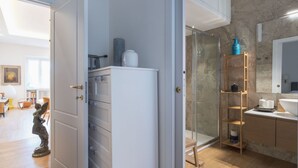 Eine moderne Küche mit einem weißen Kühlschrank, einer Duschkabine aus Glas und einer Holzeinheit.